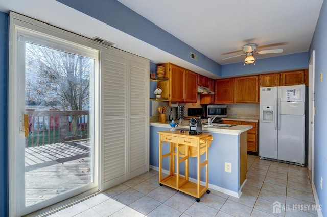 277 Edgeware Ct, Franklin, NJ 08873 - kitchen with white fridge with ice dispenser, stainless steel microwave, light countertops, a peninsula, and light tile patterned flooring