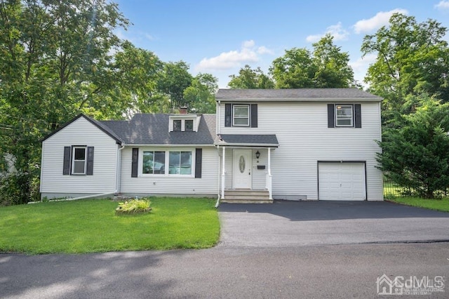 view of property with a garage and a front lawn