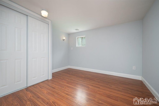 unfurnished bedroom with wood-type flooring and a closet