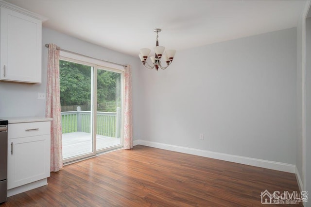 unfurnished dining area featuring dark hardwood / wood-style flooring and a notable chandelier