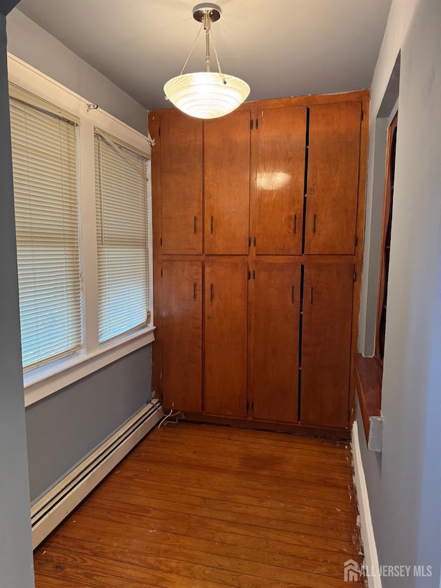 74 Spring St, Woodbridge Proper, NJ 07095 - unfurnished dining area featuring a baseboard radiator and wood finished floors