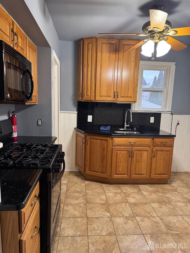 74 Spring St, Woodbridge Proper, NJ 07095 - kitchen with black appliances, brown cabinets, wainscoting, ceiling fan, and dark countertops