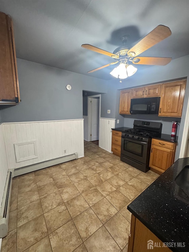 74 Spring St, Woodbridge Proper, NJ 07095 - kitchen with black microwave, gas range oven, ceiling fan, wainscoting, and a baseboard heating unit