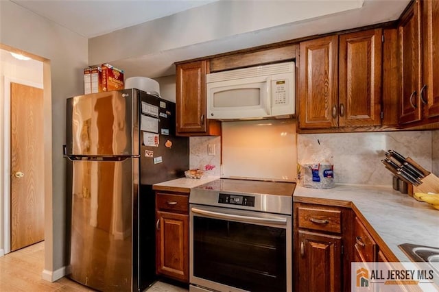 64 Netherwood Cir, Edison, NJ 08820 - kitchen featuring appliances with stainless steel finishes, light countertops, decorative backsplash, and light wood-style floors