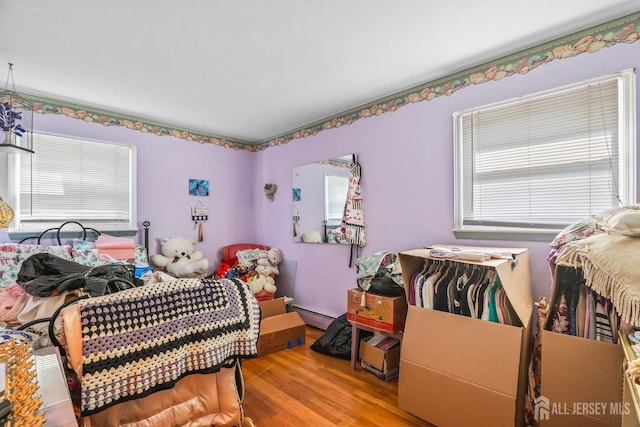 bedroom featuring a baseboard radiator and wood finished floors