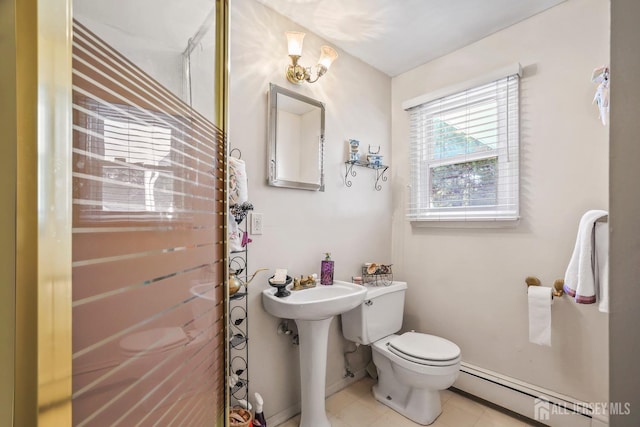 bathroom featuring baseboard heating, tile patterned flooring, a sink, and toilet