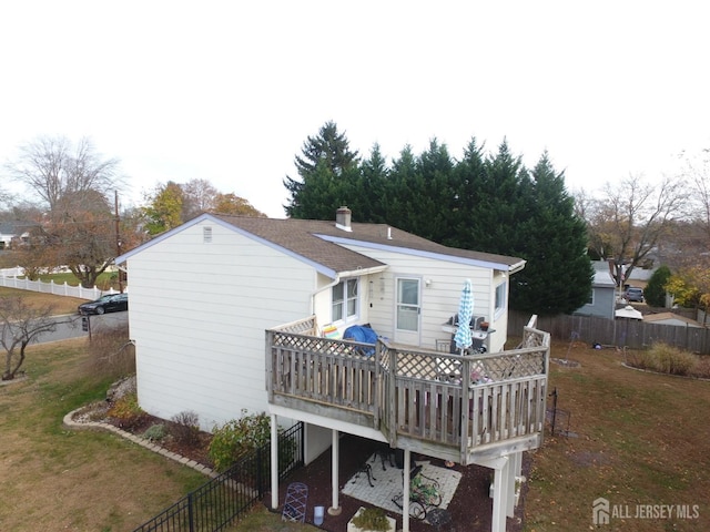 rear view of property with stairway, fence, a deck, and a yard