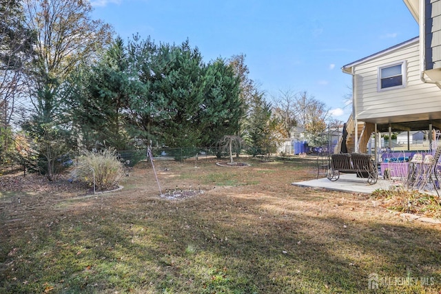 view of yard featuring a patio area, fence, and stairs