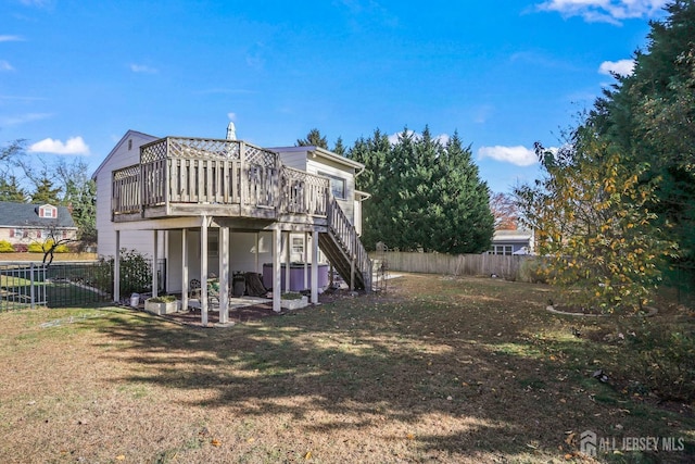 rear view of property with fence private yard, a yard, a deck, and stairs