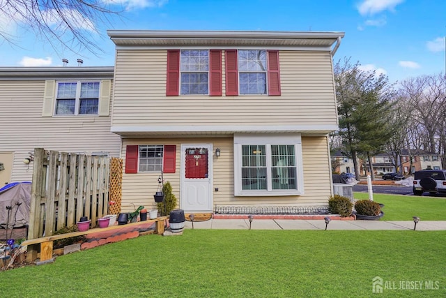 view of front of home with fence and a front lawn