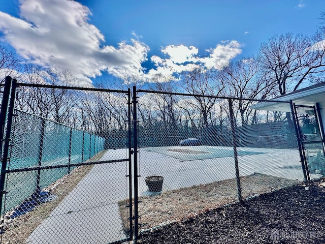 view of tennis court featuring fence