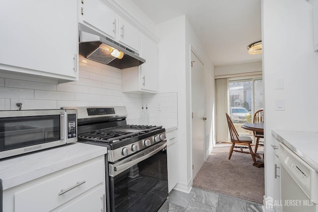 kitchen featuring tasteful backsplash, white cabinets, stainless steel appliances, light countertops, and under cabinet range hood