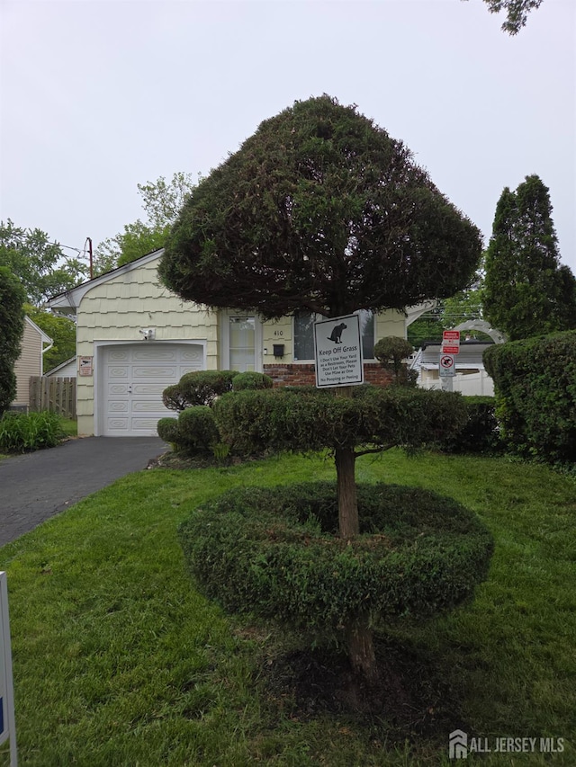 410 Harvard St, Piscataway, NJ 08854 - view of property hidden behind natural elements featuring asphalt driveway, a garage, and a front yard
