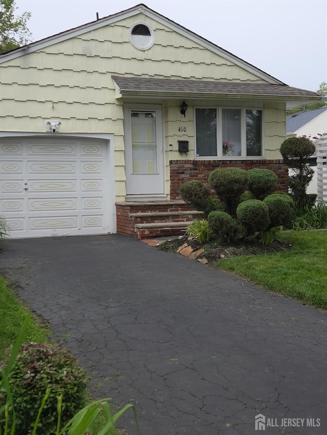 410 Harvard St, Piscataway, NJ 08854 - view of front of house featuring asphalt driveway, a garage, brick siding, and roof with shingles