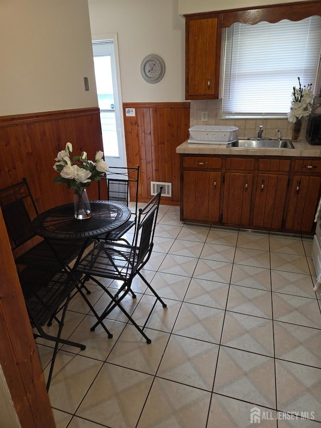 410 Harvard St, Piscataway, NJ 08854 - kitchen featuring wainscoting, wooden walls, light countertops, and brown cabinetry