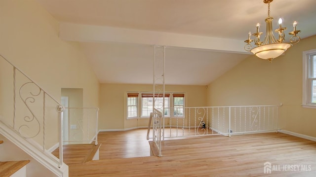 1487 Columbia Dr, North Brunswick, NJ 08902 - unfurnished dining area with wood finished floors, lofted ceiling, a chandelier, and baseboards