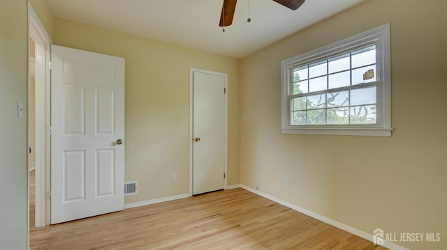 unfurnished bedroom with wood finished floors, baseboards, and ceiling fan