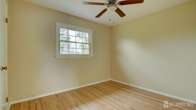spare room featuring wood finished floors, baseboards, and ceiling fan