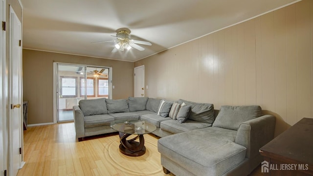 living area with ceiling fan, light wood-style flooring, and baseboards