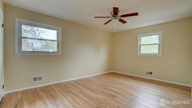 empty room featuring wood finished floors, baseboards, and a ceiling fan