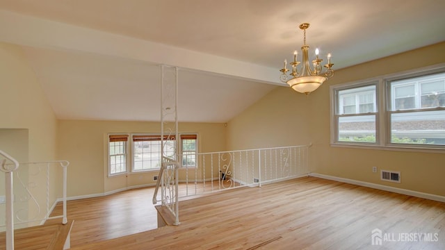 1487 Columbia Dr, North Brunswick, NJ 08902 - unfurnished dining area featuring wood finished floors, lofted ceiling, a chandelier, and baseboards