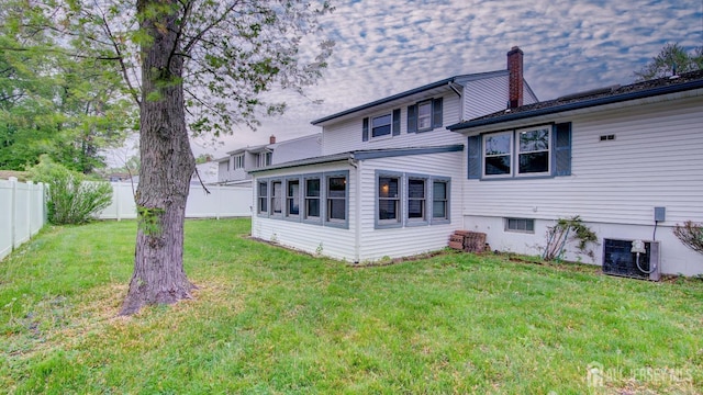 rear view of house with a chimney and central AC unit