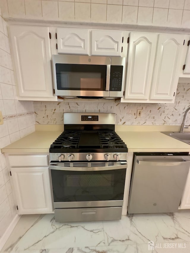 16 Sassafras Ct, North Brunswick, NJ 08902 - kitchen with appliances with stainless steel finishes, light countertops, light marble finish floors, and white cabinetry