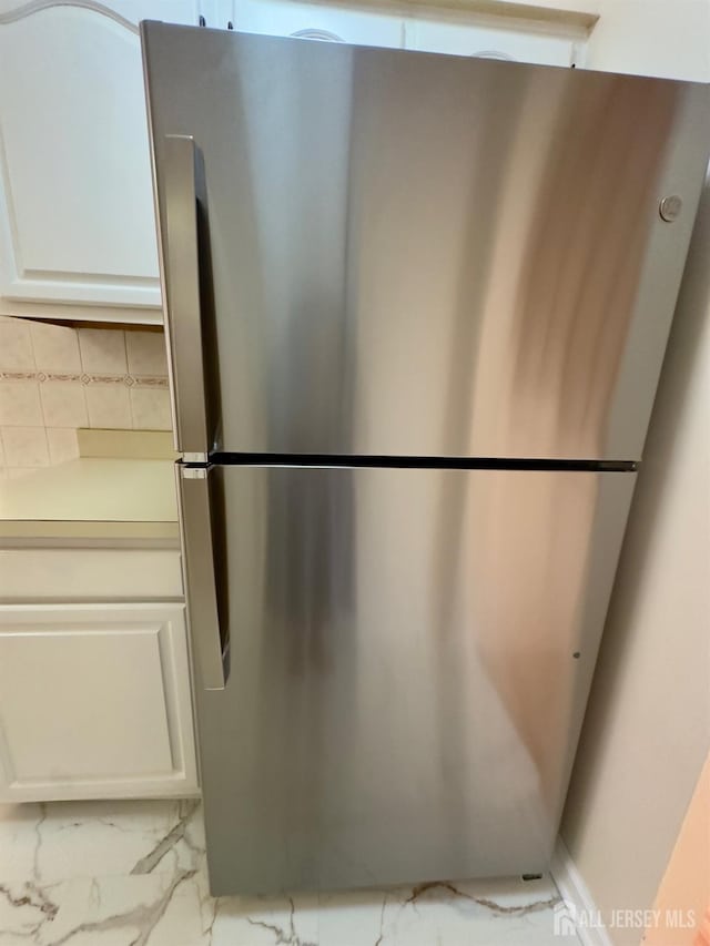 16 Sassafras Ct, North Brunswick, NJ 08902 - detailed view of freestanding refrigerator, white cabinetry, light countertops, and tasteful backsplash