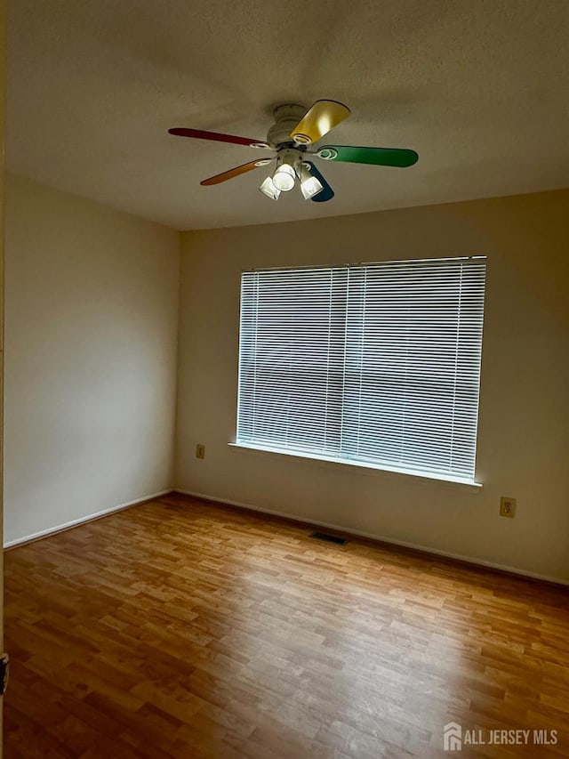 16 Sassafras Ct, North Brunswick, NJ 08902 - empty room featuring a ceiling fan, wood finished floors, and a textured ceiling