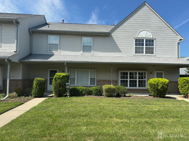 16 Sassafras Ct, North Brunswick, NJ 08902 - traditional home featuring brick siding, a front yard, a shingled roof, and a porch