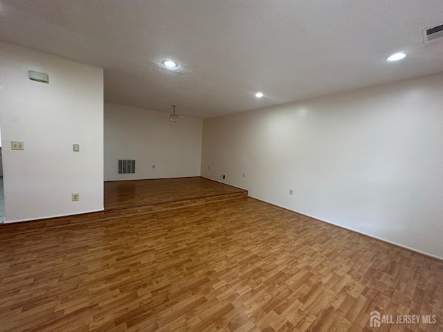 16 Sassafras Ct, North Brunswick, NJ 08902 - unfurnished room with light wood finished floors, a textured ceiling, and recessed lighting