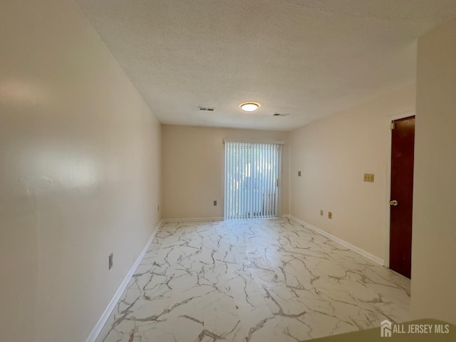 16 Sassafras Ct, North Brunswick, NJ 08902 - empty room with light marble finish floors and a textured ceiling
