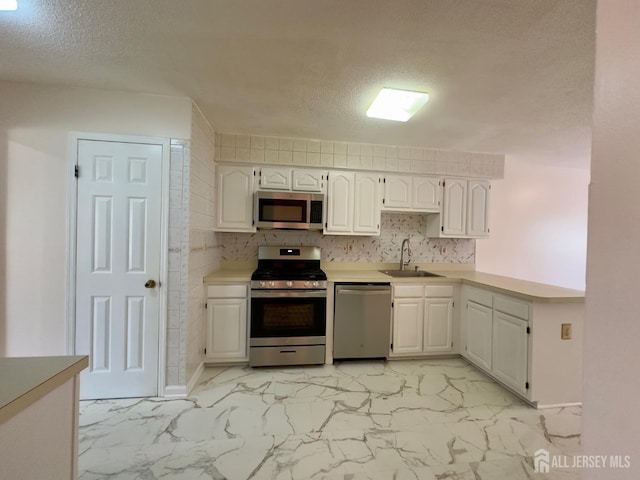 16 Sassafras Ct, North Brunswick, NJ 08902 - kitchen featuring stainless steel appliances, a textured ceiling, light marble finish floors, white cabinetry, and light countertops