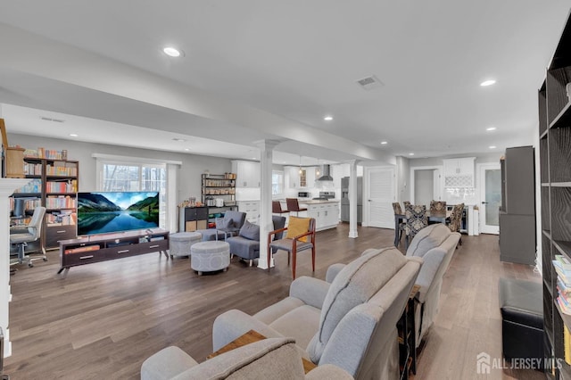 living room with recessed lighting, decorative columns, visible vents, and wood finished floors