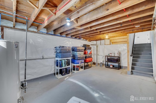 unfinished basement featuring gas water heater and stairway