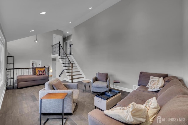 living room featuring stairway, baseboards, high vaulted ceiling, and hardwood / wood-style floors