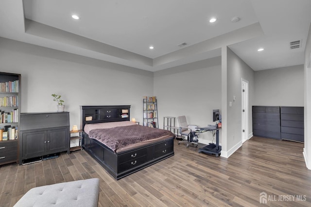 bedroom with recessed lighting, visible vents, baseboards, and wood finished floors