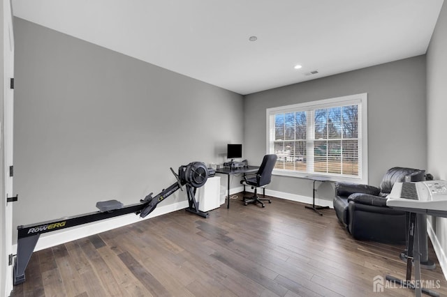 office space with visible vents, baseboards, and hardwood / wood-style flooring