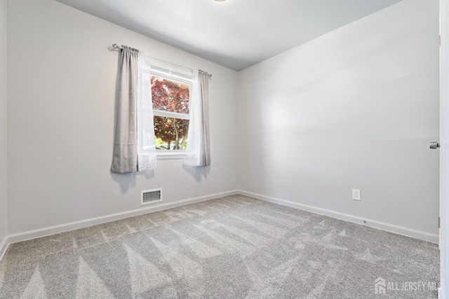 carpeted spare room with baseboards and visible vents