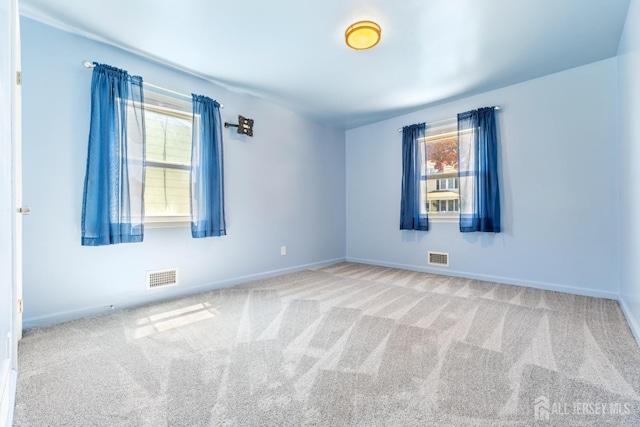 spare room with baseboards, visible vents, and carpet floors