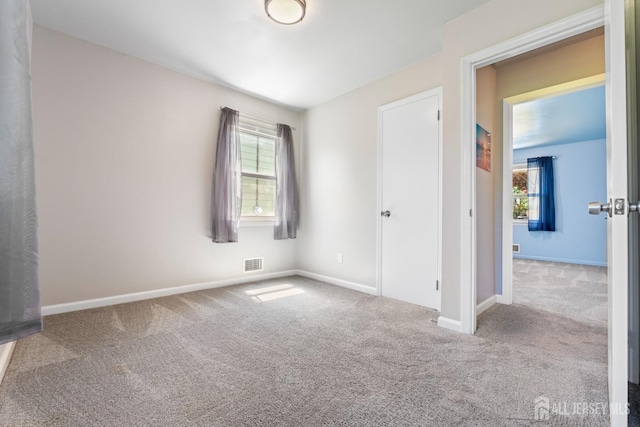 unfurnished bedroom with carpet, visible vents, and baseboards