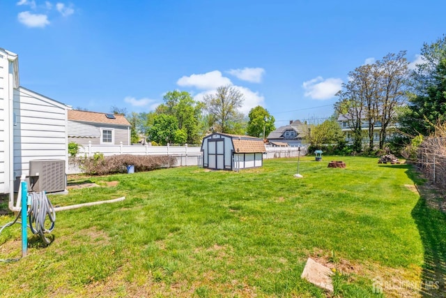 view of yard with central AC, an outdoor structure, a shed, and a fenced backyard