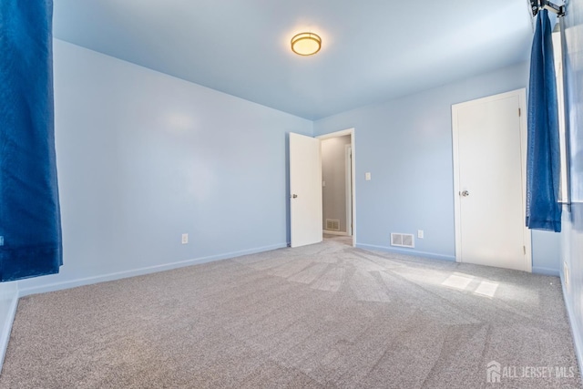 unfurnished bedroom with visible vents, baseboards, and light carpet
