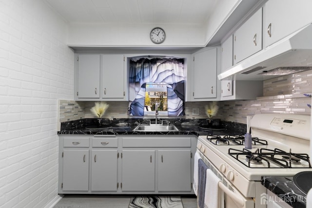 kitchen featuring under cabinet range hood, backsplash, a sink, and white range with gas cooktop