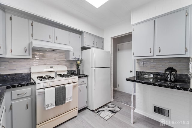kitchen with light wood-style flooring, visible vents, white appliances, under cabinet range hood, and decorative backsplash