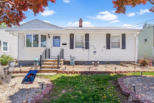 view of front of property with a chimney and central AC unit