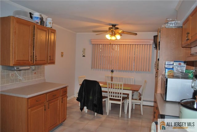 dining space with ceiling fan and ornamental molding