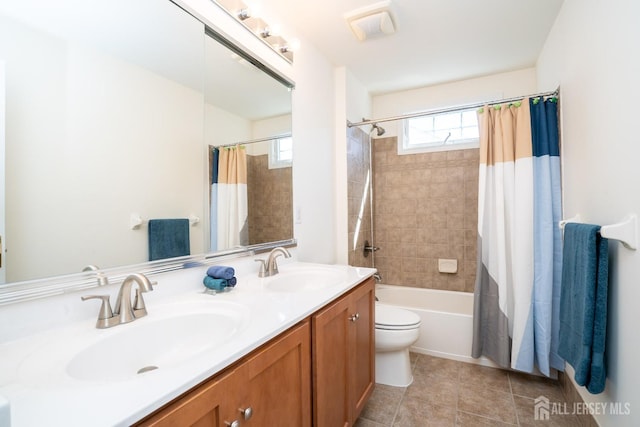 bathroom featuring double vanity, shower / bath combo, a sink, and tile patterned floors