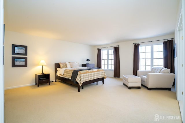 bedroom featuring light carpet and baseboards