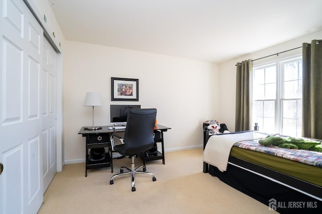 carpeted bedroom featuring a closet and baseboards